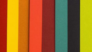 Papel de colores cortados en linea verticales y sobre puestas, rojo, amarillo, ocre, naranja, marrón, verde, negro y verde limón
